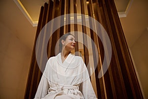 Portrait of a relaxed serene attractive elegant middle aged 30- 40 years old European woman in white terry robe enjoying vacation