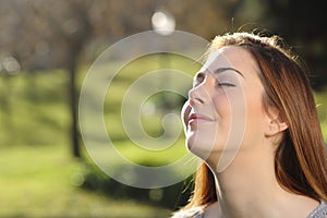 Portrait of a relaxed woman breathing deep in a park