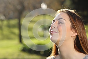 Portrait of a relaxed woman breathing deep in a park photo