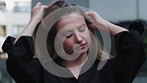 Portrait of relaxed woman looking straight at camera in sunlight. Closeup smiling girl playing with hair . Beautiful