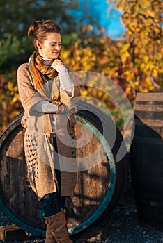 Portrait of relaxed woman winemaker standing in autumn vineyard