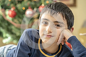 Portrait of relaxed young boy on christmas morning near his tree
