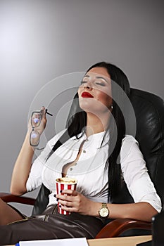 Portrait of a relaxed young businesswoman sitting with legs on d