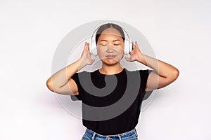 Portrait of relaxed young woman listening to music in headphones