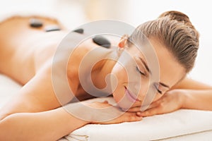 Portrait of relaxed young woman receiving hot stone massage