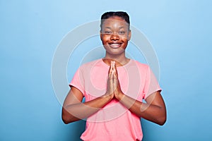 Portrait of religious african american student praying to god asking for forgiveness