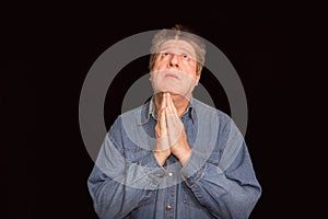Portrait of a religious expressive man praying in studio