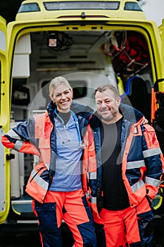 Portrait of rescuers in front of ambulance car.