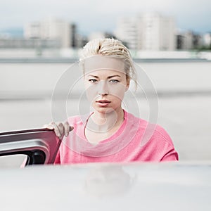 Portrait of responsible female driver holding car keys in her hand. Safe driving school