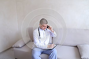 Portrait of responsible male doctor who communicates on cell and