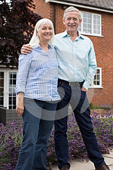 Portrait Of Retired Couple Standing Outside Home