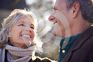 Portrait Of Retired Senior Couple Enjoying Winter Walk Through Village In Countryside Together