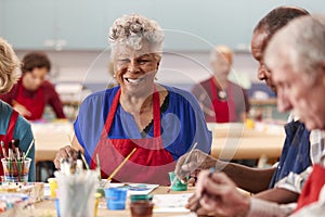 Portrait Of Retired Senior Woman Attending Art Class In Community Centre