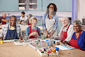 Portrait Of Retired Seniors Attending Art Class In Community Centre With Teacher