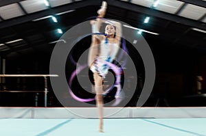 Portrait, ribbon and motion blur with a black woman gymnast in a studio for olympics dance training or exercise. Fitness