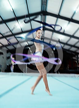 Portrait, ribbon and motion blur with a woman gymnast in a studio for olympics dance training or exercise. Fitness, art