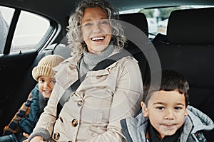 Portrait, road trip and grandmother travel with children or grandchildren and relax on a car ride in the backseat