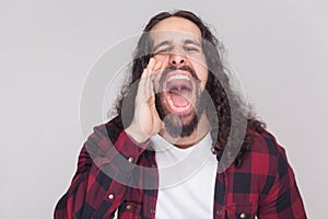 Portrait of roar handsome man with beard and black long curly ha