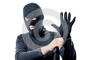 Portrait of a robber in a mask on his face straightens a glove photo