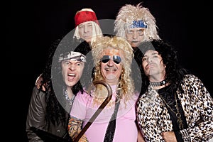 Portrait of rock musicians making funny faces over black background