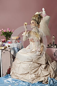Portrait of rococo woman dressed as Marie Antoinette holding cake