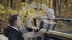 Portrait of romantic couple looks on each other at retro car