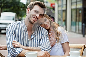 Portrait of romantic couple sitting at sidewalk cafe