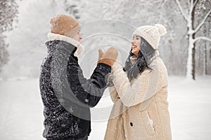 Portrait of romantic couple spending time together in forest at winter day