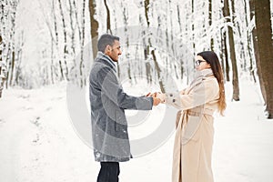 Portrait of a romantic couple spending time together in winter forest