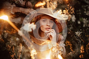 Portrait of a romantic girl in a blooming garden with elements of phantasmagoria.