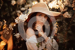 Portrait of a romantic girl in a blooming garden with elements of phantasmagoria.