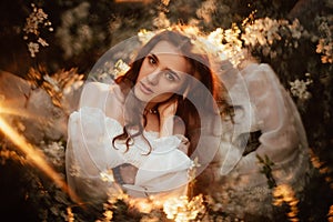 Portrait of a romantic girl, like a forest fairy, in a blooming garden with elements of phantasmagoria. The concept of