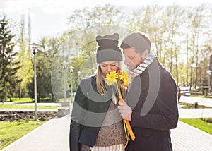 Portrait of romantic man giving flowers to woman