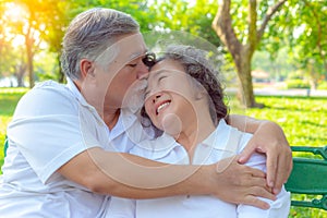 Portrait romantic older couple. Attractive handsome older husband embracing and kissing his older wife with love. Grandfather and