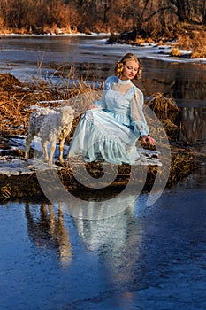 Portrait of romantic woman in a dress on the bank of the river