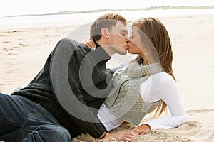 Portrait Of Romantic Young Couple Kissing On Beach