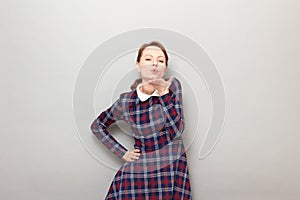 Portrait of romantic young woman blowing air kiss to you