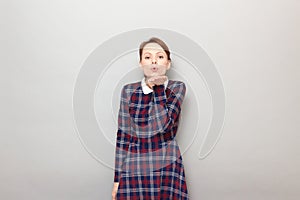 Portrait of romantic young woman blowing air kiss to you