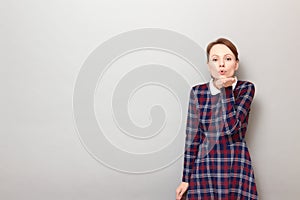 Portrait of romantic young woman blowing air kiss to you