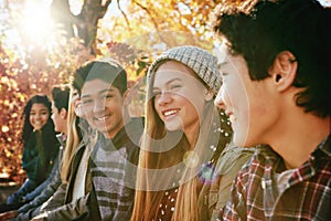 Portrait, row and friends outdoor in park for relaxing day on summer vacation of semester break, together and bonding photo