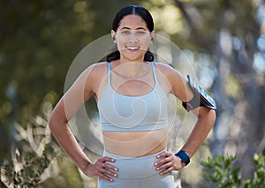 Portrait, runner and happy woman, arm band and earphones of music, motivation or fitness in nature, sports and cardio