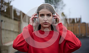 Portrait of running woman after jogging in the park on autumn seasson. Female fitness model training outside on a cozy