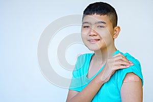 Portrait rural Asian boy standing against white background looking camera smiling happily after vaccinating against coronavirus in