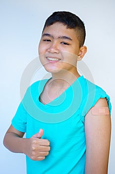 Portrait of a rural Asian boy standing against a white background looking at the camera smiling happy thumbs up presses Like after