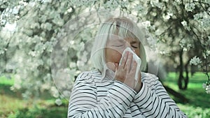 Portrait of sad 50s european woman stand sneezecoughs feel sick fever flu coronavirus symptoms cold allergy city