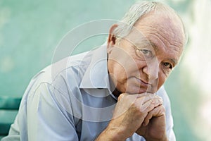 Portrait of sad bald senior man looking at camera