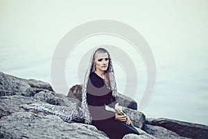 Portrait of sad beautiful Caucasian white young bald girl woman with shaved hair head covered with scarf shawl looking away