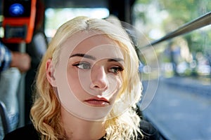 Portrait of a sad beautiful young woman who rides in a trolleybus