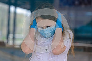 Portrait of sad caucasian child in face mask on closed playground outdoor. Coronavirus social distance quarantine