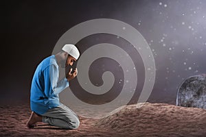 Portrait of sad crying young asian muslim man with beard pray on graveyard cemetery